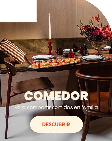 Mesa de comedor puesta con platos, vasos, velas y un ramo de flores en un ambiente acogedor